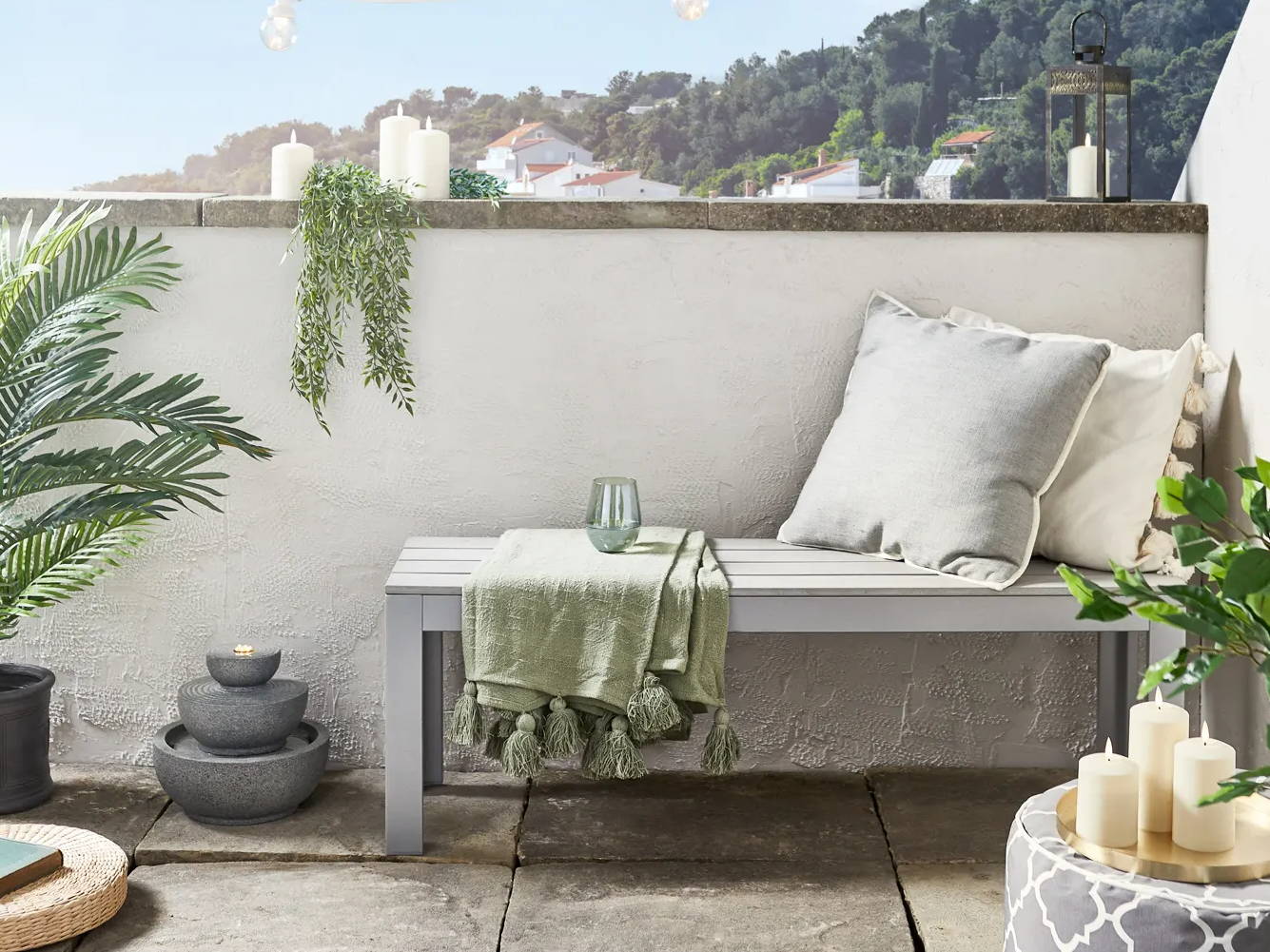 Rustic balcony with  candles, festoon lights and a water feature displayed