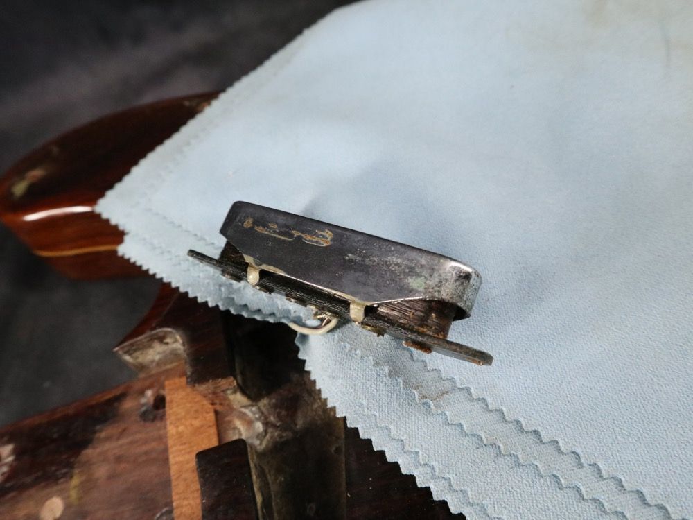 A metal clip resting on a light blue fabric surface.