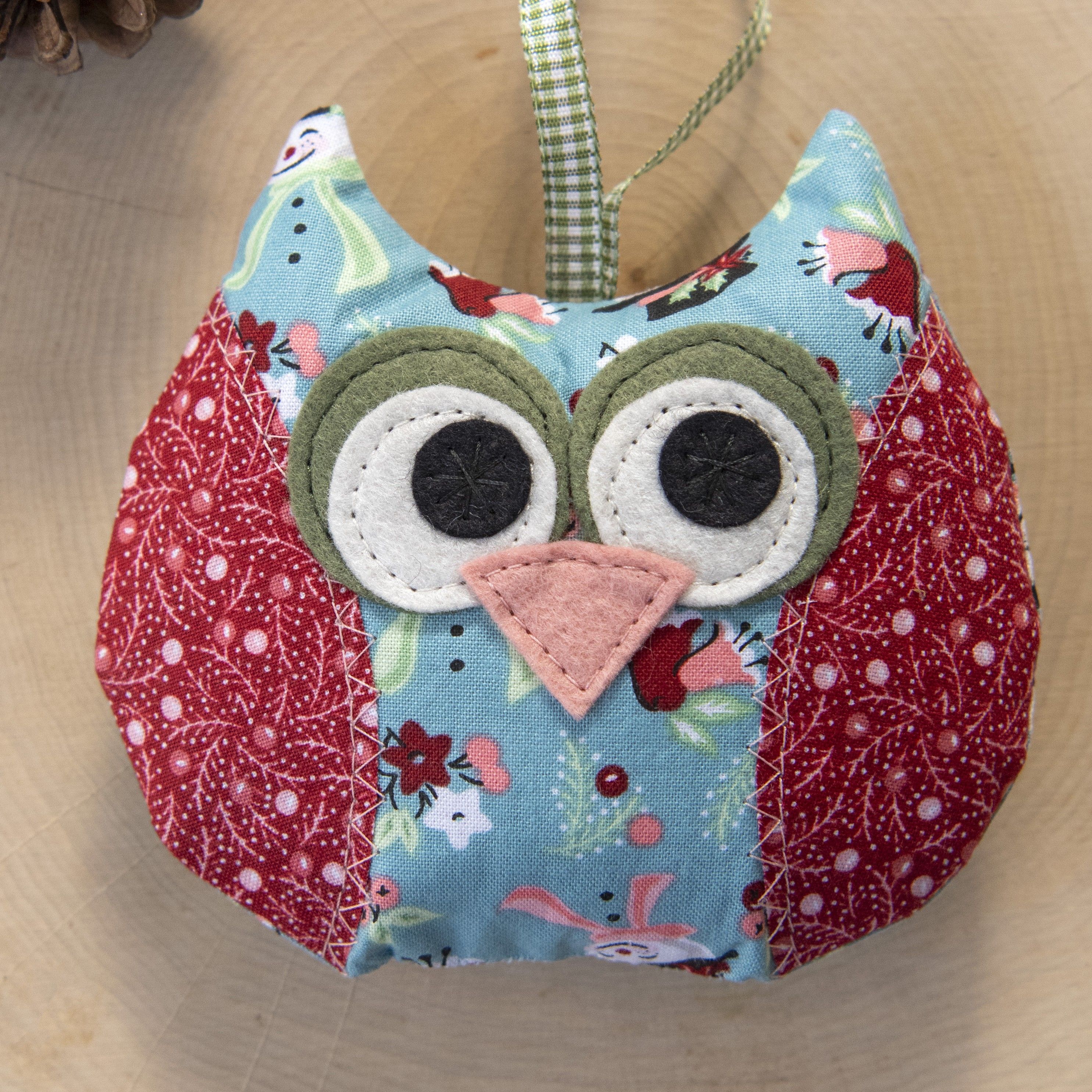 Colorful fabric owl decoration with large eyes and a pink beak.