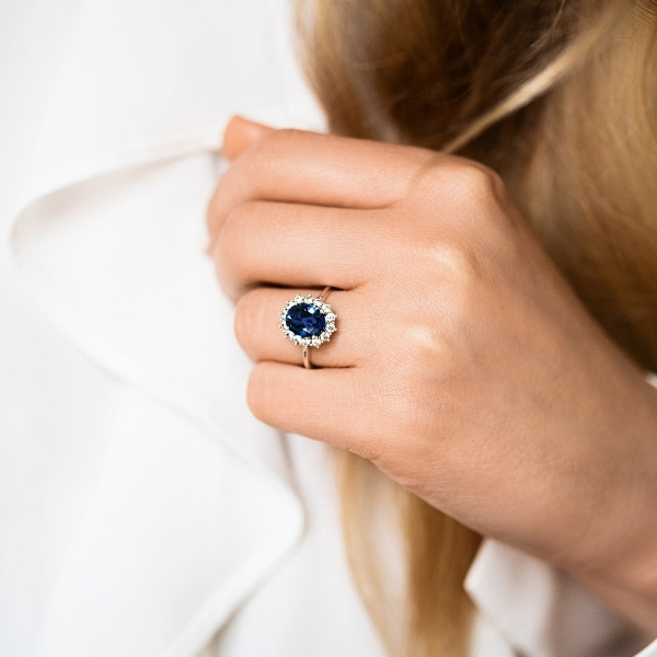 an elegant diamond accented engagement ring with an oval shaped blue sapphire