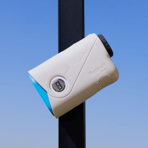 A white and orange camera mounted on a pole against a blue sky.