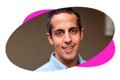 Smiling man in a light blue shirt with a pink background.