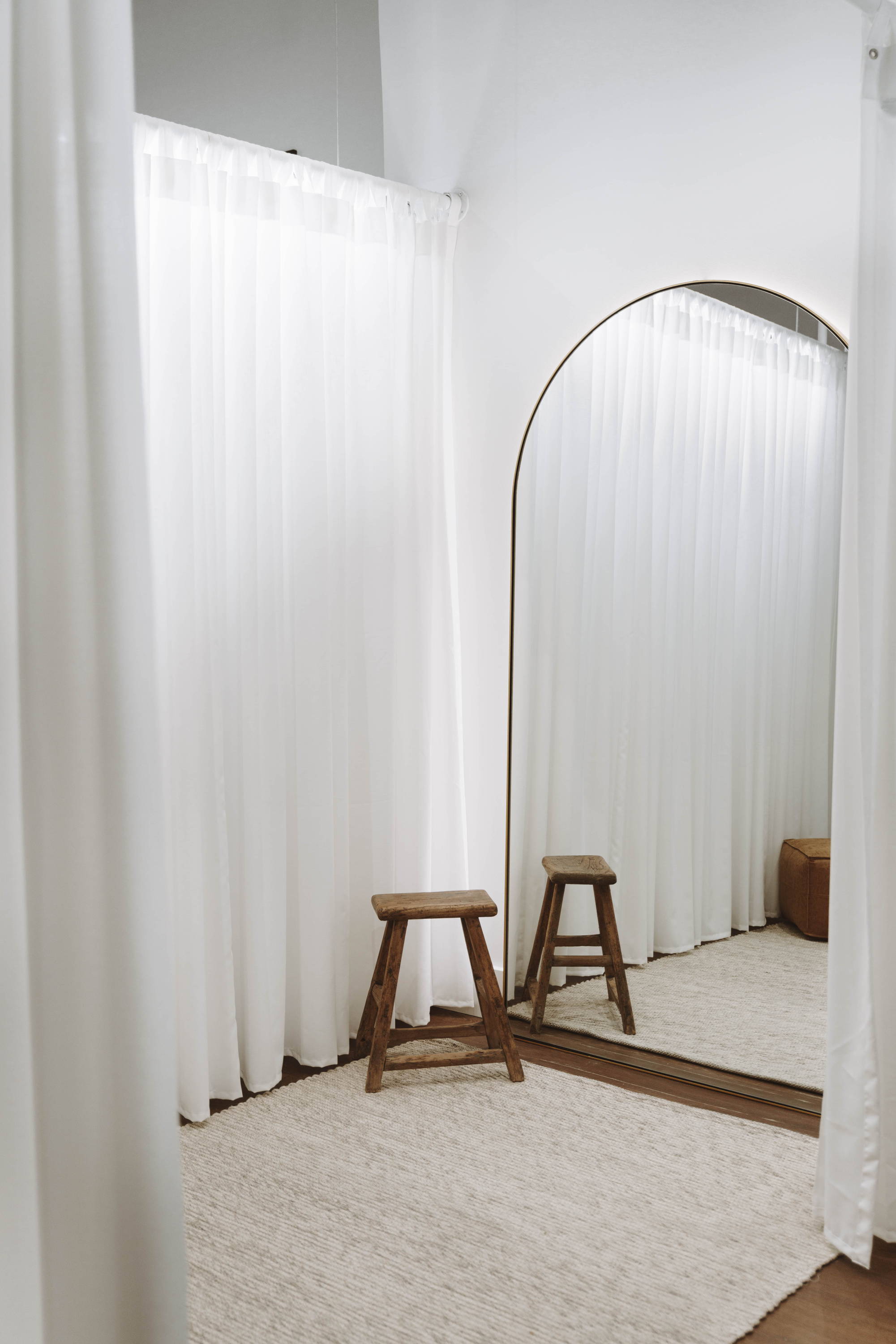 Einfacher durchsichtiger Vorhang und Holzhocker im Ankleidezimmer der Braut