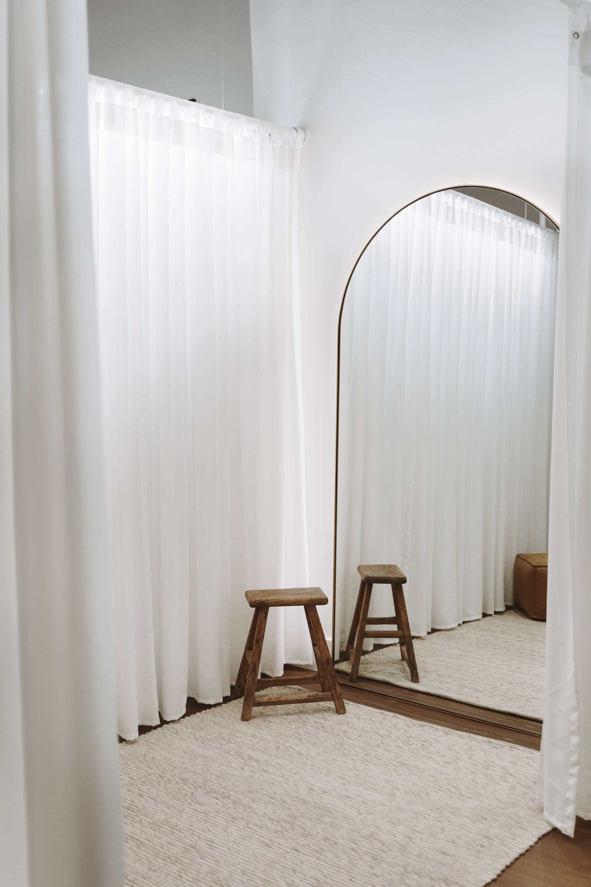 Un simple rideau transparent et un tabouret en bois dans la loge de la mariée.