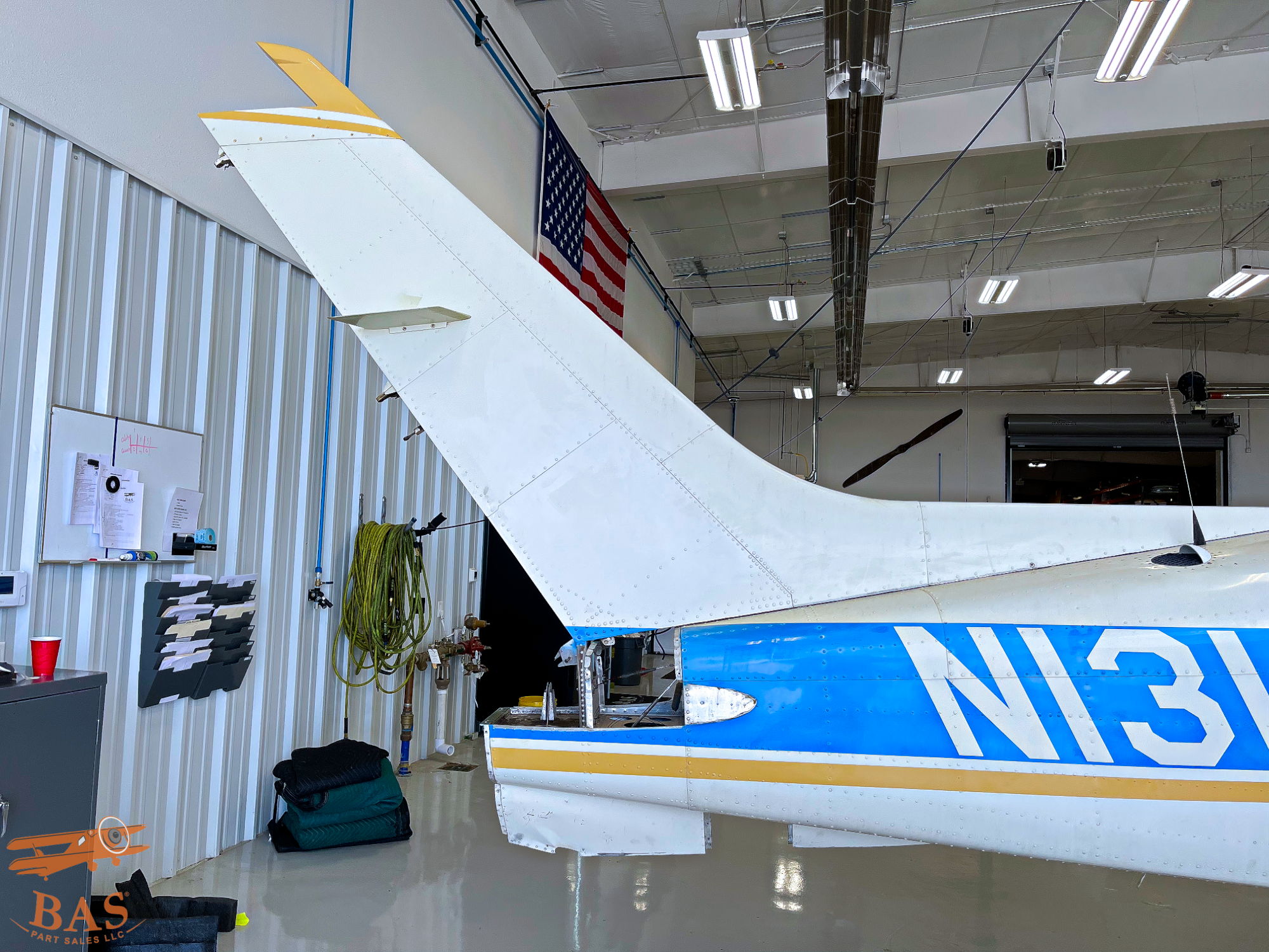 Tail section of a small aircraft inside a hangar.