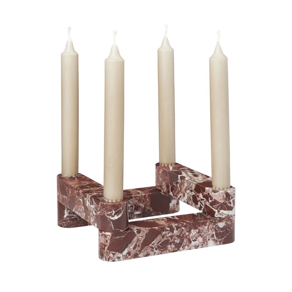 A marble candle holder with four white candles.