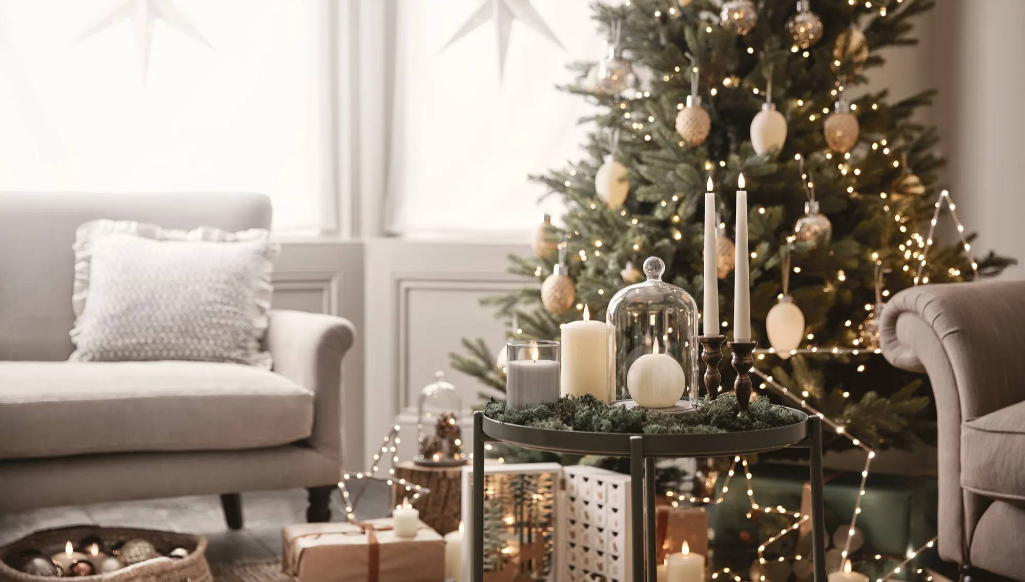 A Christmas tree in the background with LED candles and star lights as decorations.