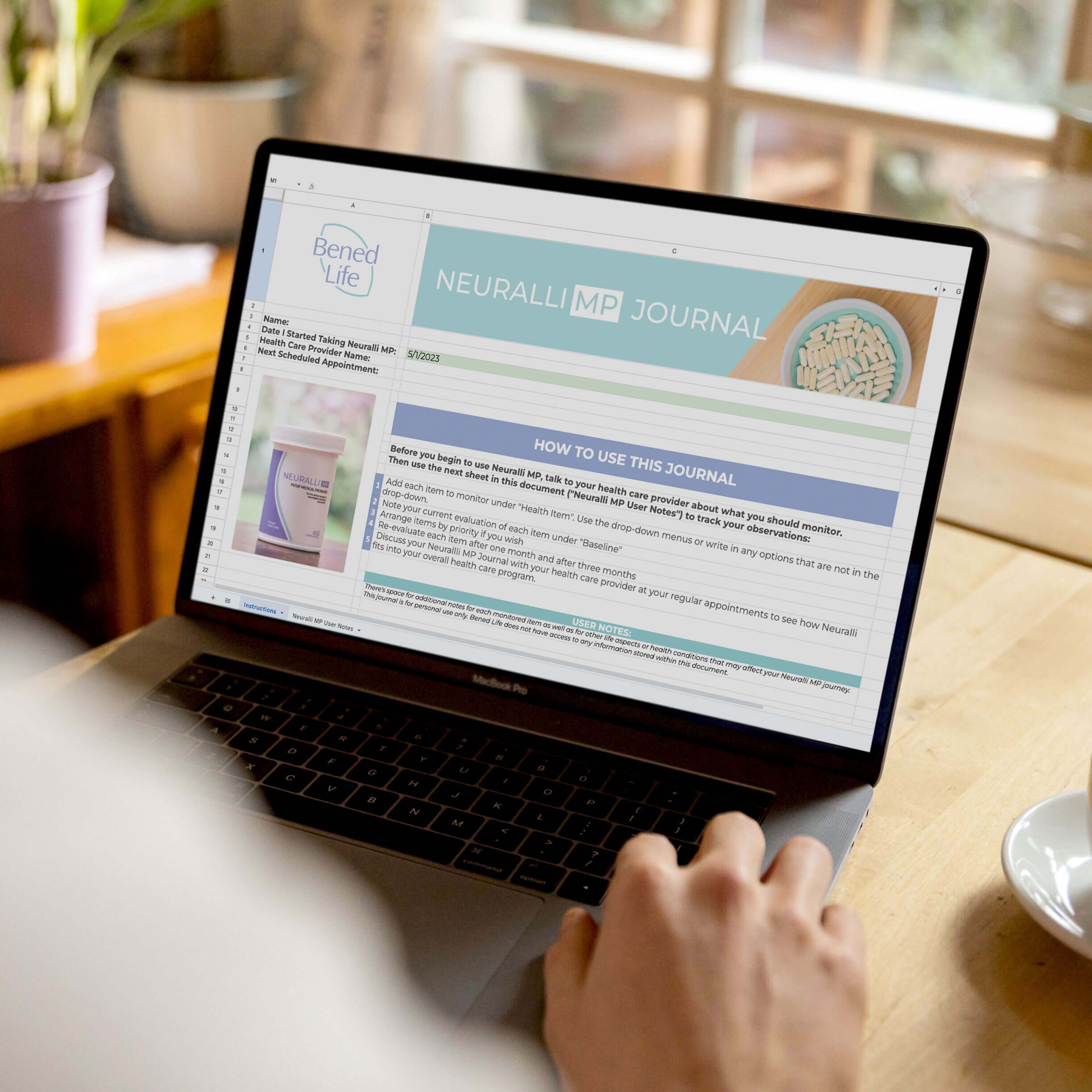 Person using a laptop displaying a website at a wooden table.