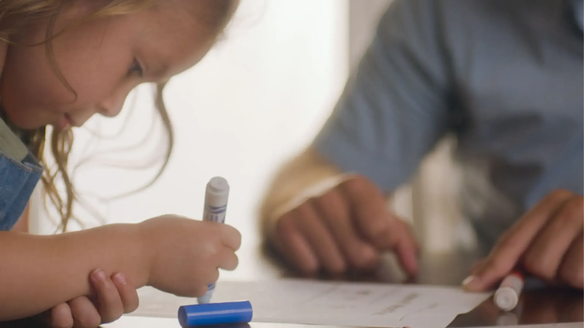 Man with child writing on paper