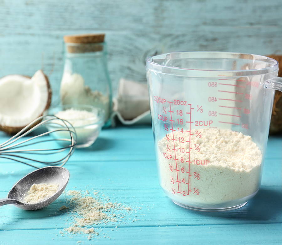 baking supplies with coconut flour in measuring cup