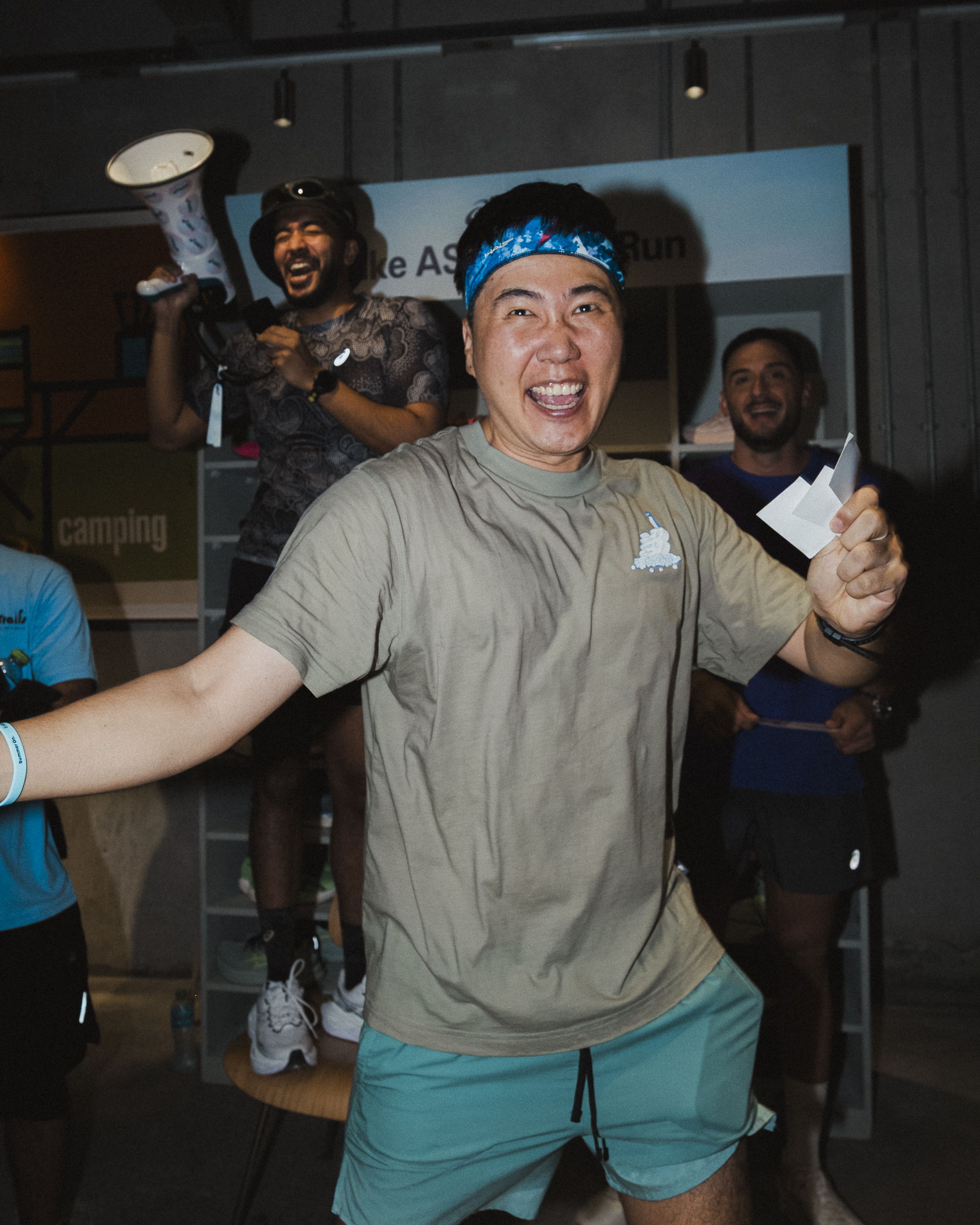 Participants celebrating and enjoying the ASICS raffle during the Global Running Day event with FRAME RUN CLUB in Dubai Design District.