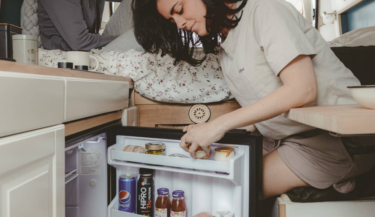 woman opens a indel b fridge / refrigerator