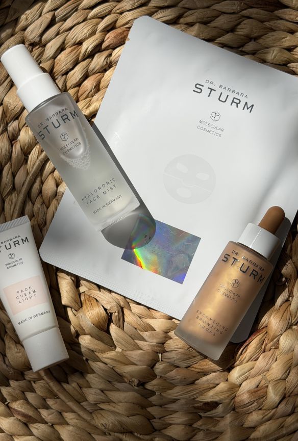 Skincare products on a woven surface, including serum and face mask.