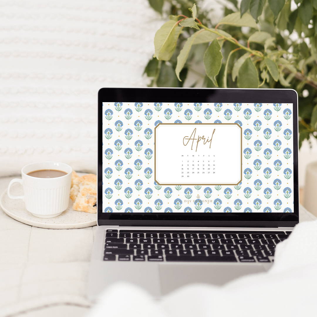 april 2024 digital wallpaper in repeated blue and green floral design on laptop. with white coffee mug and green plant
