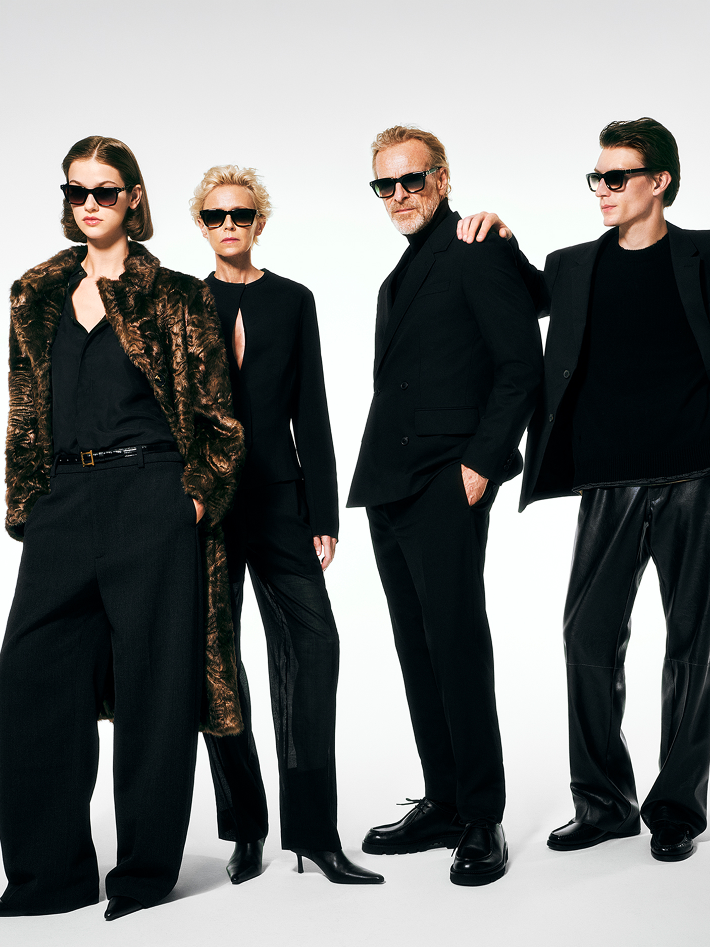 Four stylish individuals in black outfits and Robert Marc sunglasses posing together.
