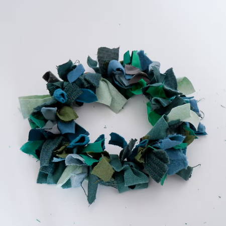 a finished wreath made out of green fabric scraps