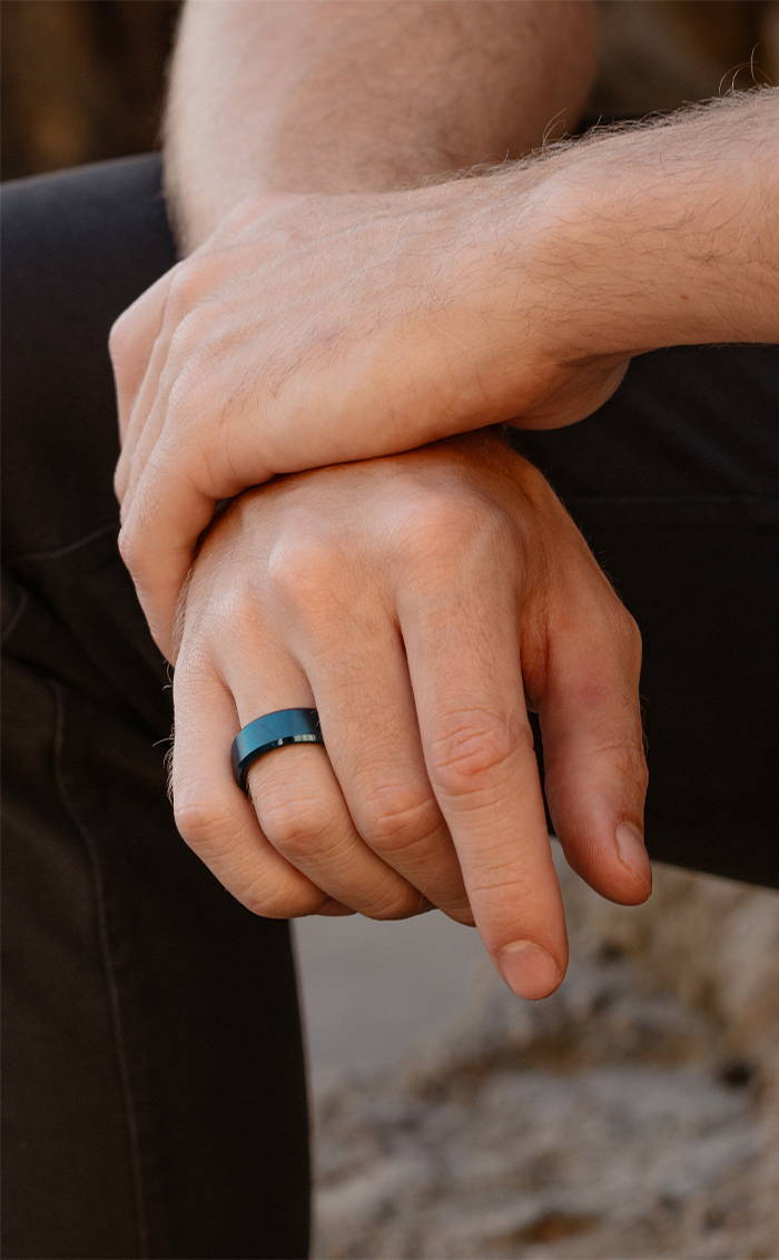 man crossing hands with a Gunmetal 8MM Beveled Ring in his finger