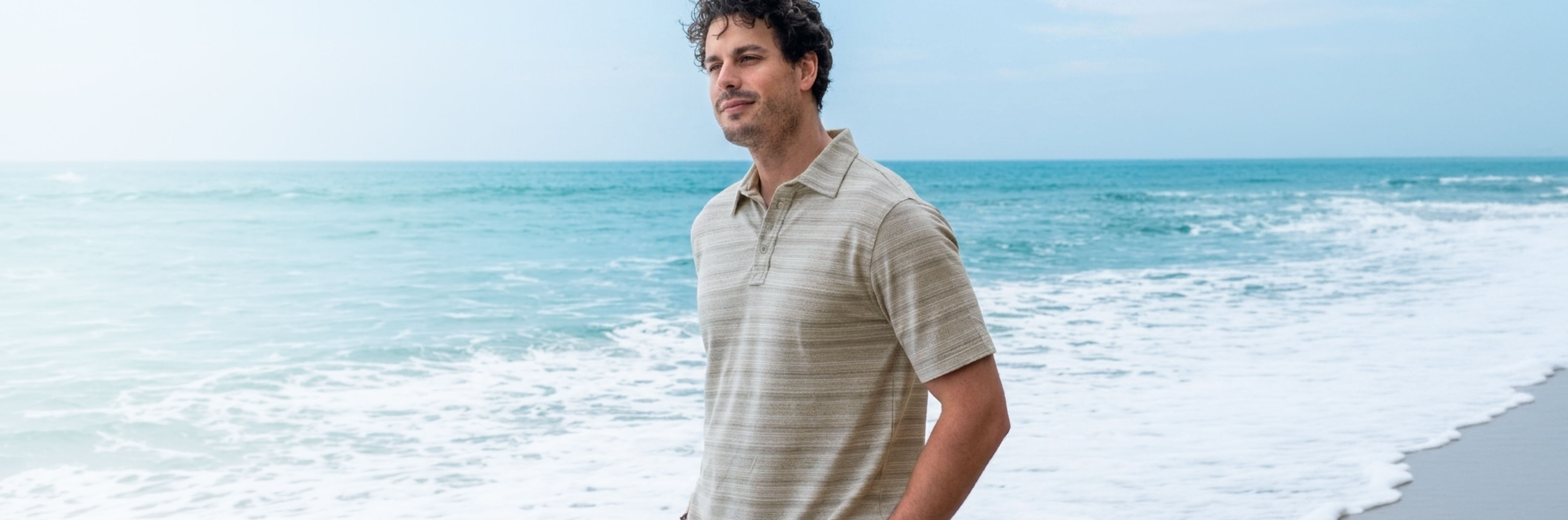 a man wearing a cariloha polo on the beach