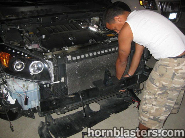 Installer working behind radiator bumper removed V6 engine Wesley's 2008 RAV4 Conductor's Special 228H horn mount gallery photo 5