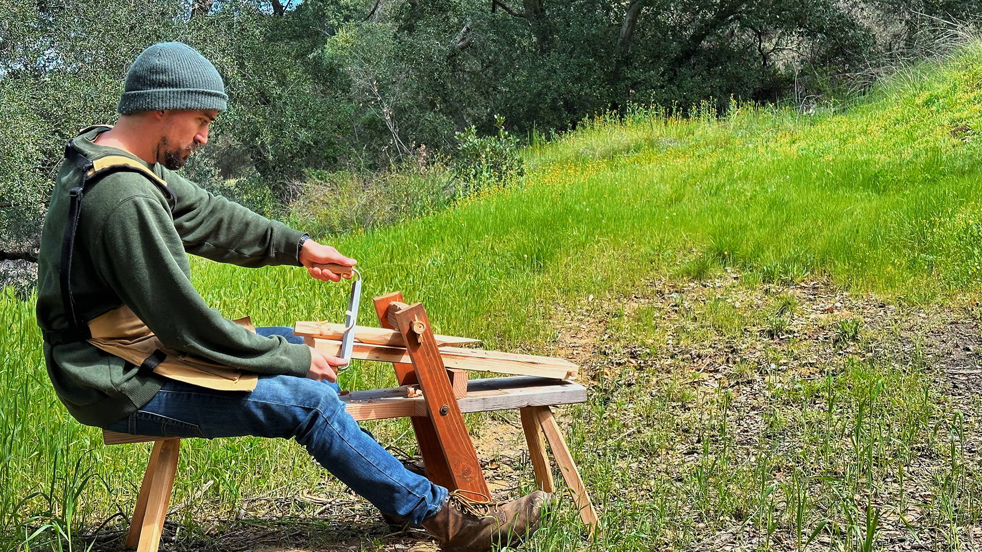 man cutting wood with a drawknife on a shave  horse