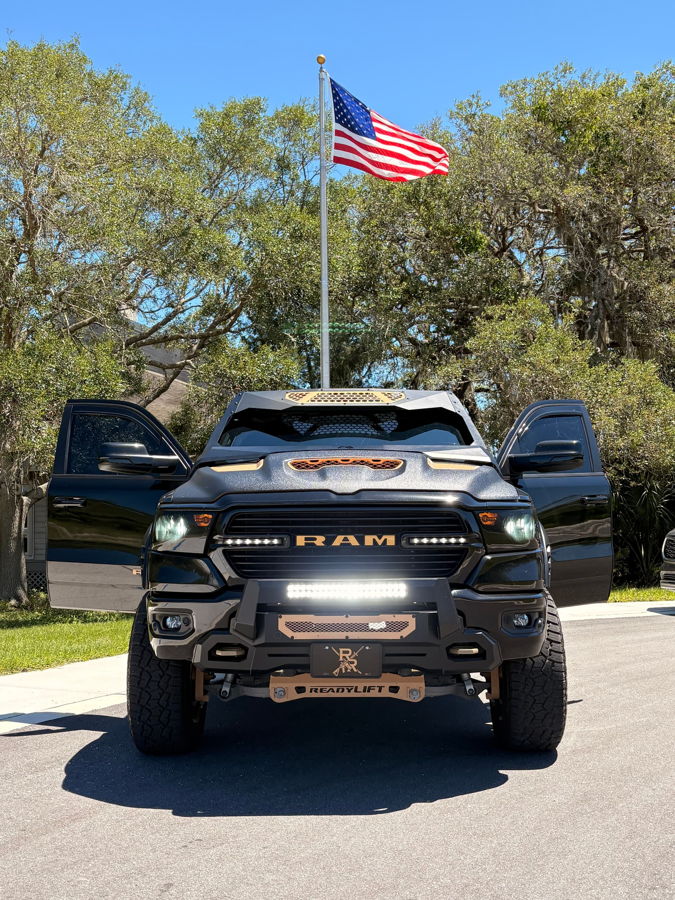 Front view Pedro's 2021 Ram Bighorn 1500 with doors open custom grille LED bars and American flag Conductor's Special 232 train horn install gallery photo 2