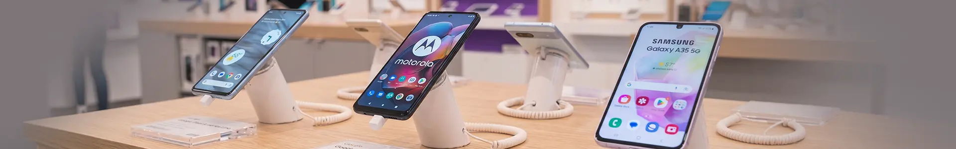 Three affordable student smartphones compared side by side in store.