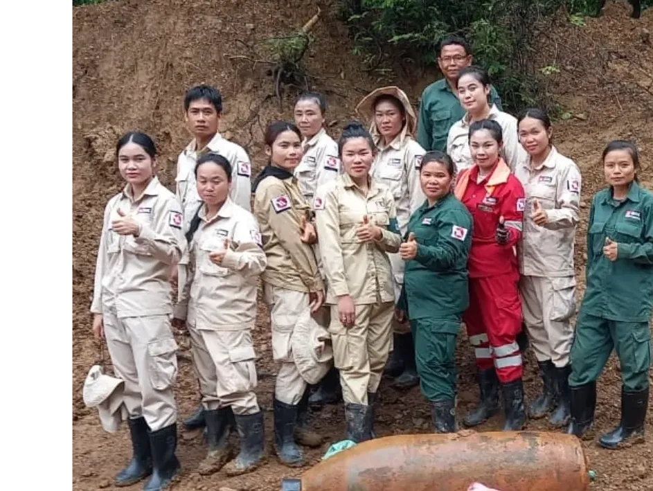 Group of people in work uniforms posing outdoors.