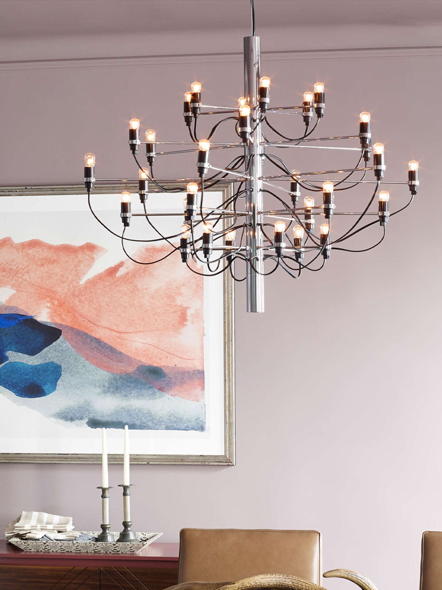 Flos 2097 Chandelier hanging above a dining table with abstract wall art.