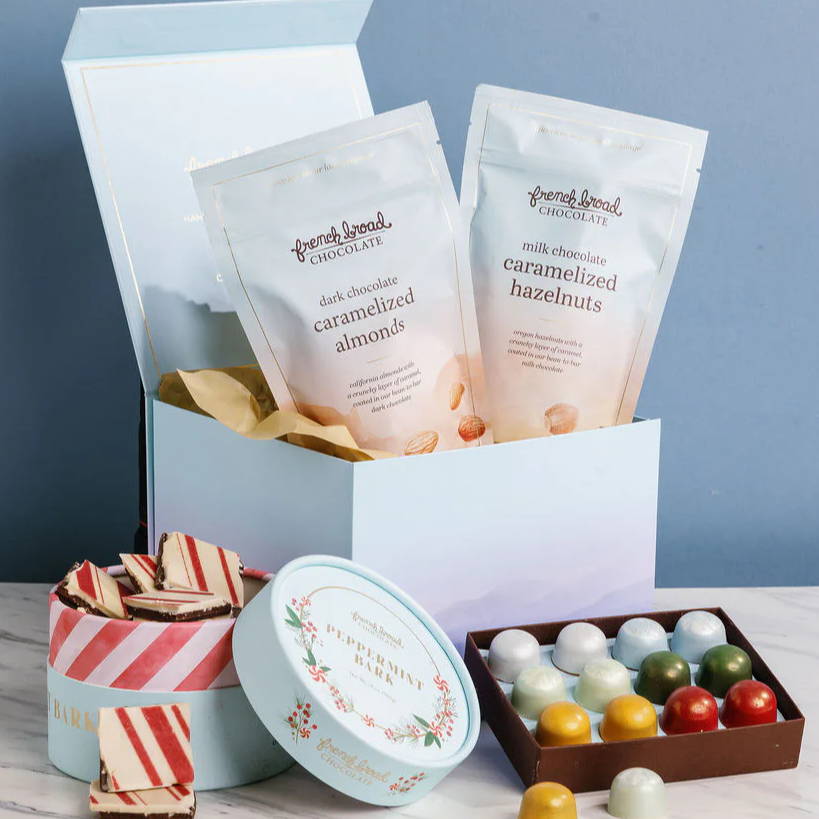 Gift box with assorted treats, including candies and snacks.