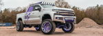Front three-quarter Ismael's lifted silver Chevrolet Silverado Z71 with purple suspension and skull graphic photo 1