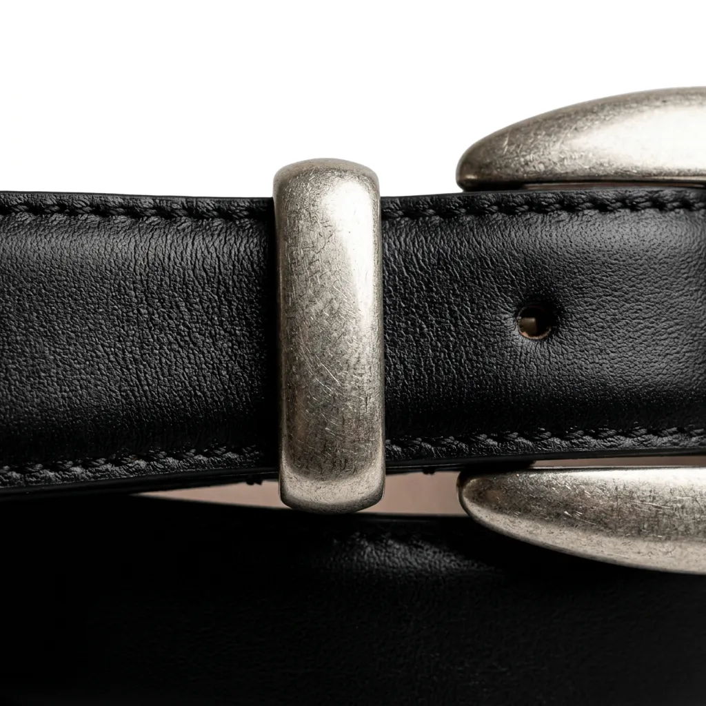 Close-up of a black leather belt with a silver buckle.