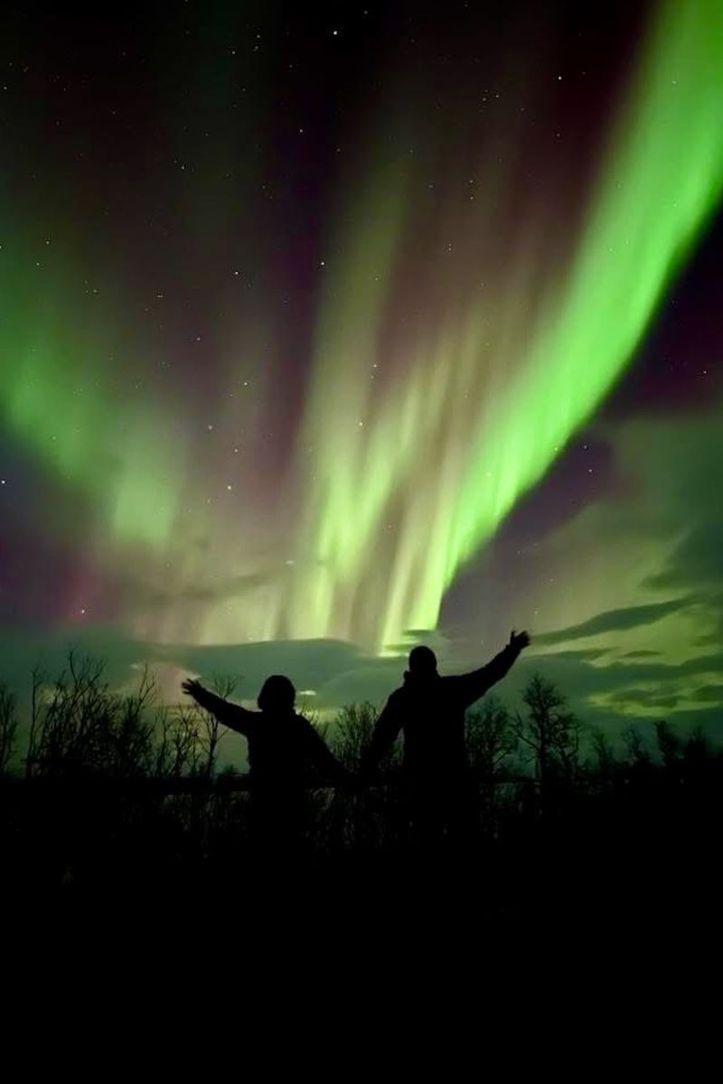 couple getting engaged with northern lights in background