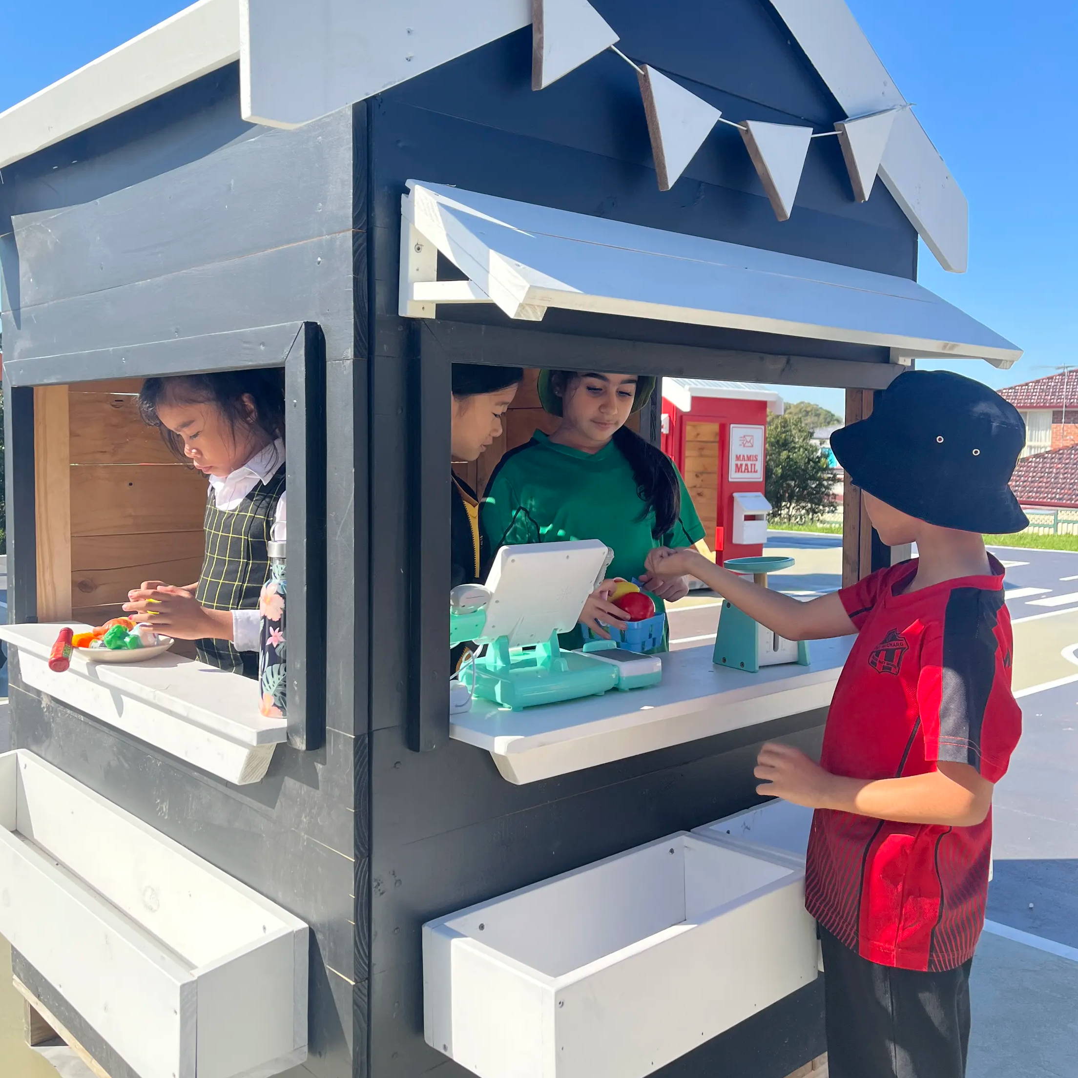 Children engaging in an imaginative play with a painted cubby house.