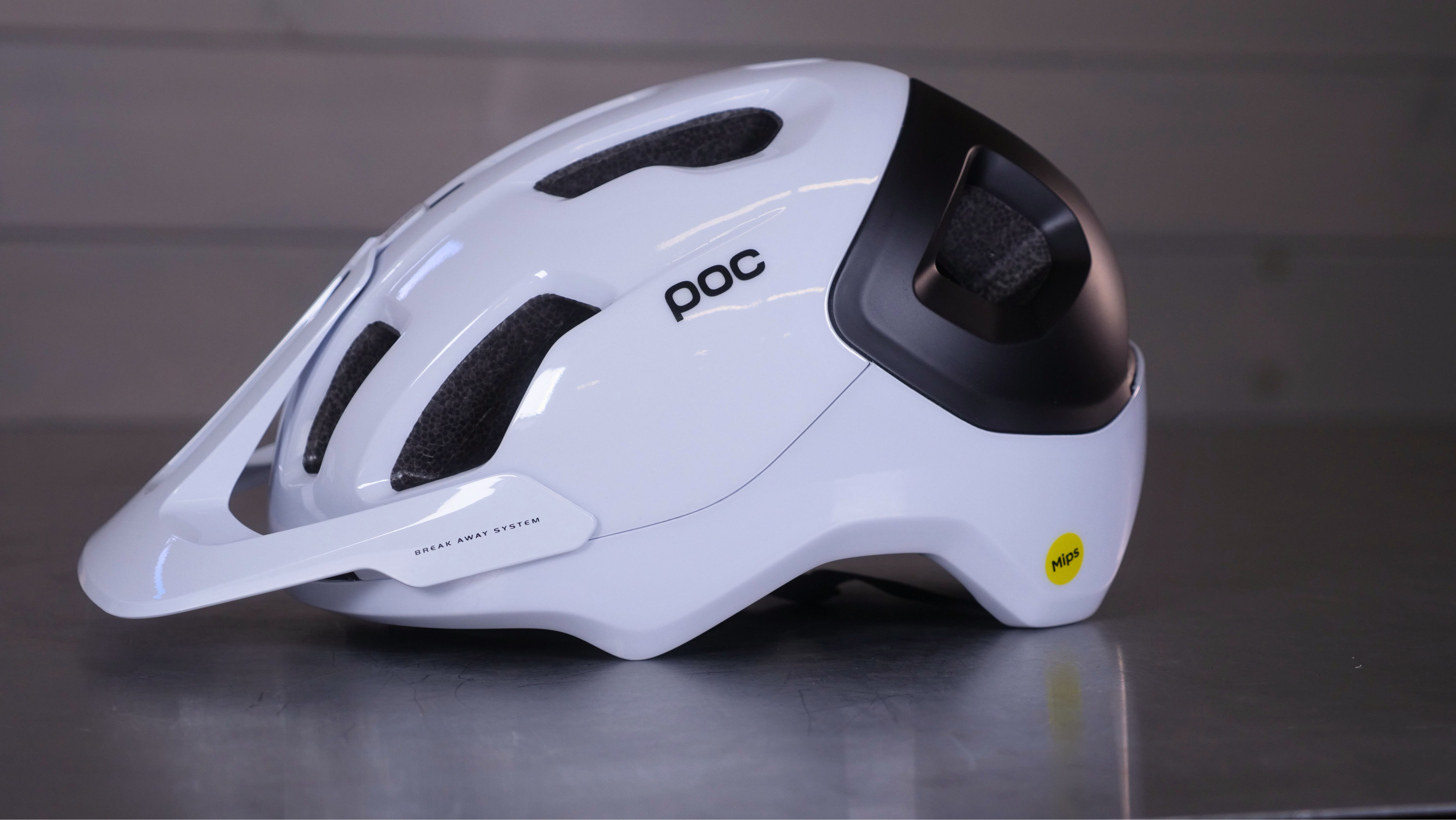 White bicycle helmet with ventilation holes and black accents.