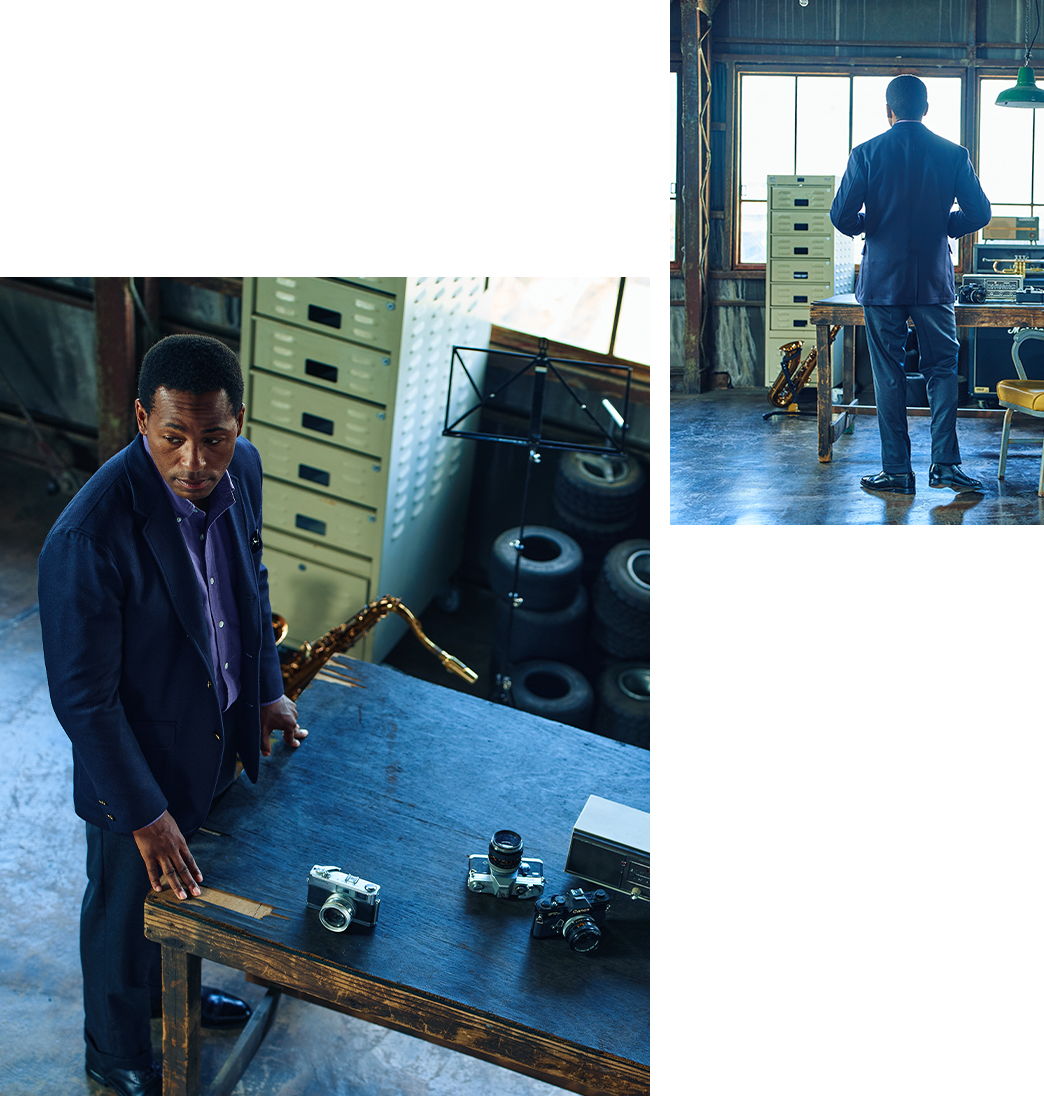 A man stands at a table with cameras in a workshop setting.