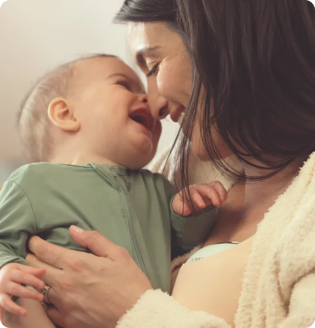 Mom and baby having an intimate moment while mom uses the Mother's Nature™ W1 Warming Wearable Breast Pump 
