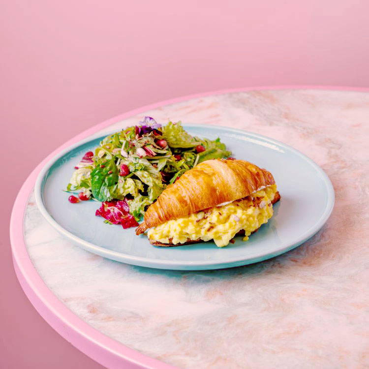 Loaded Croissant with salad on blue plate