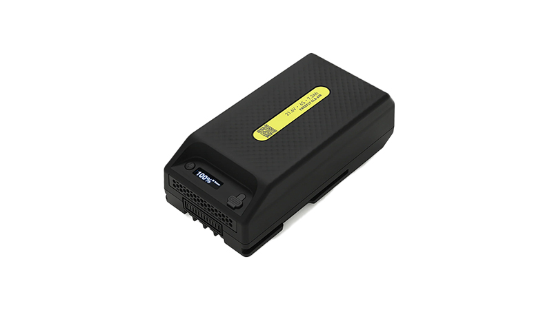 Batterie rectangulaire noire avec une étiquette jaune sur le dessus.