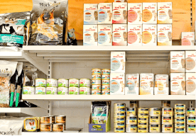 Shelves stocked with various pet food products and supplies.