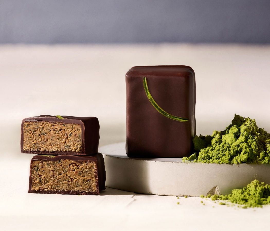 Chocolaty dessert with matcha powder and two cut pieces.