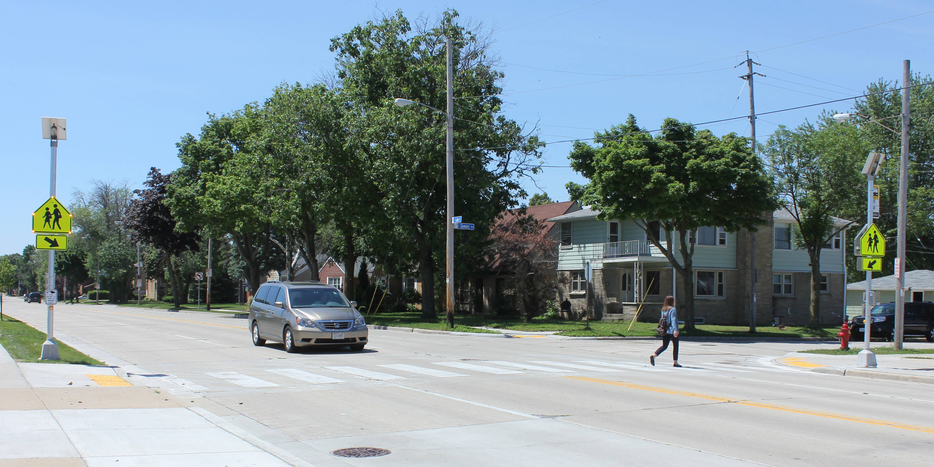 School zone crosswalk with pedestrian and car.