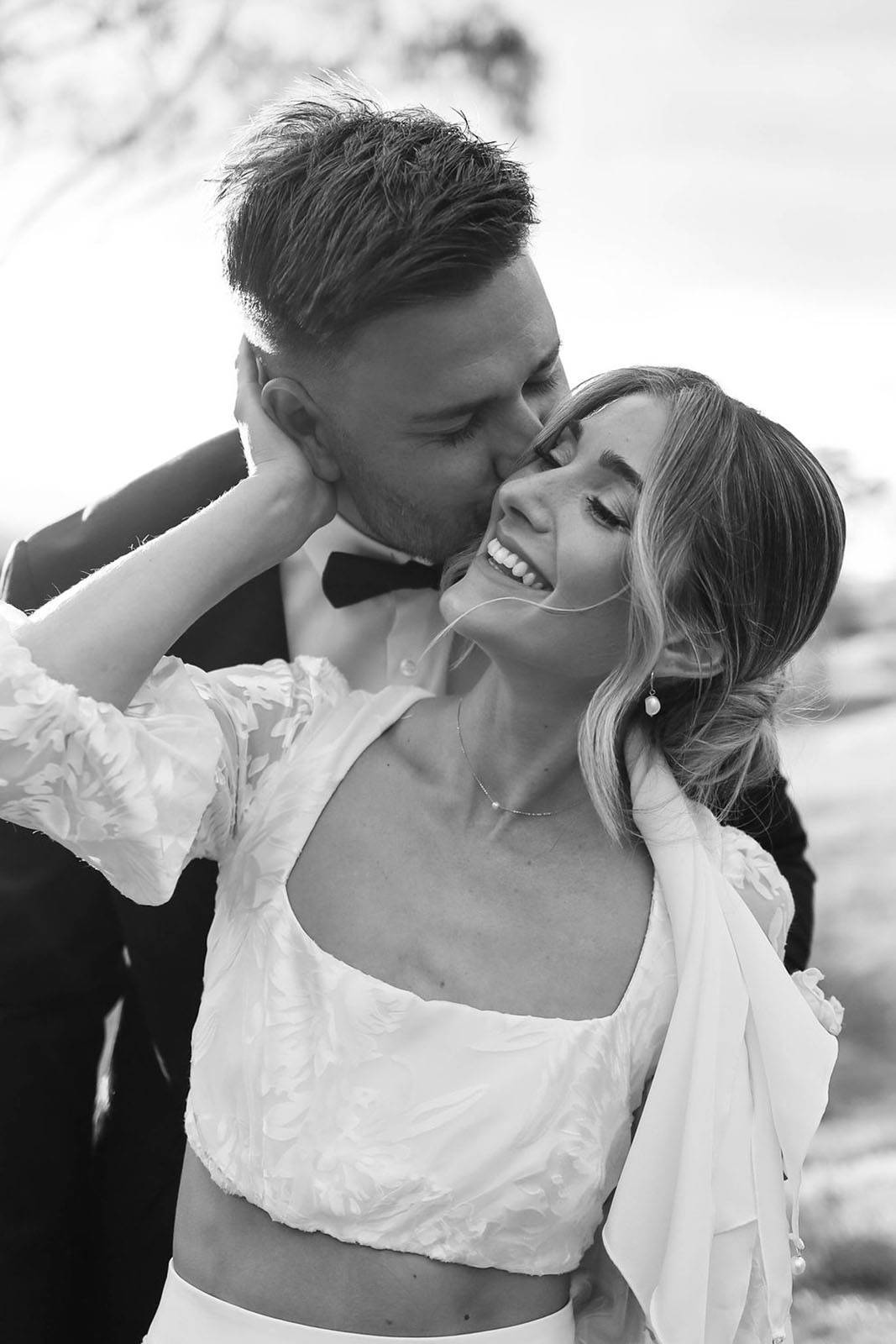 Groom affectionately kissing bride's cheek