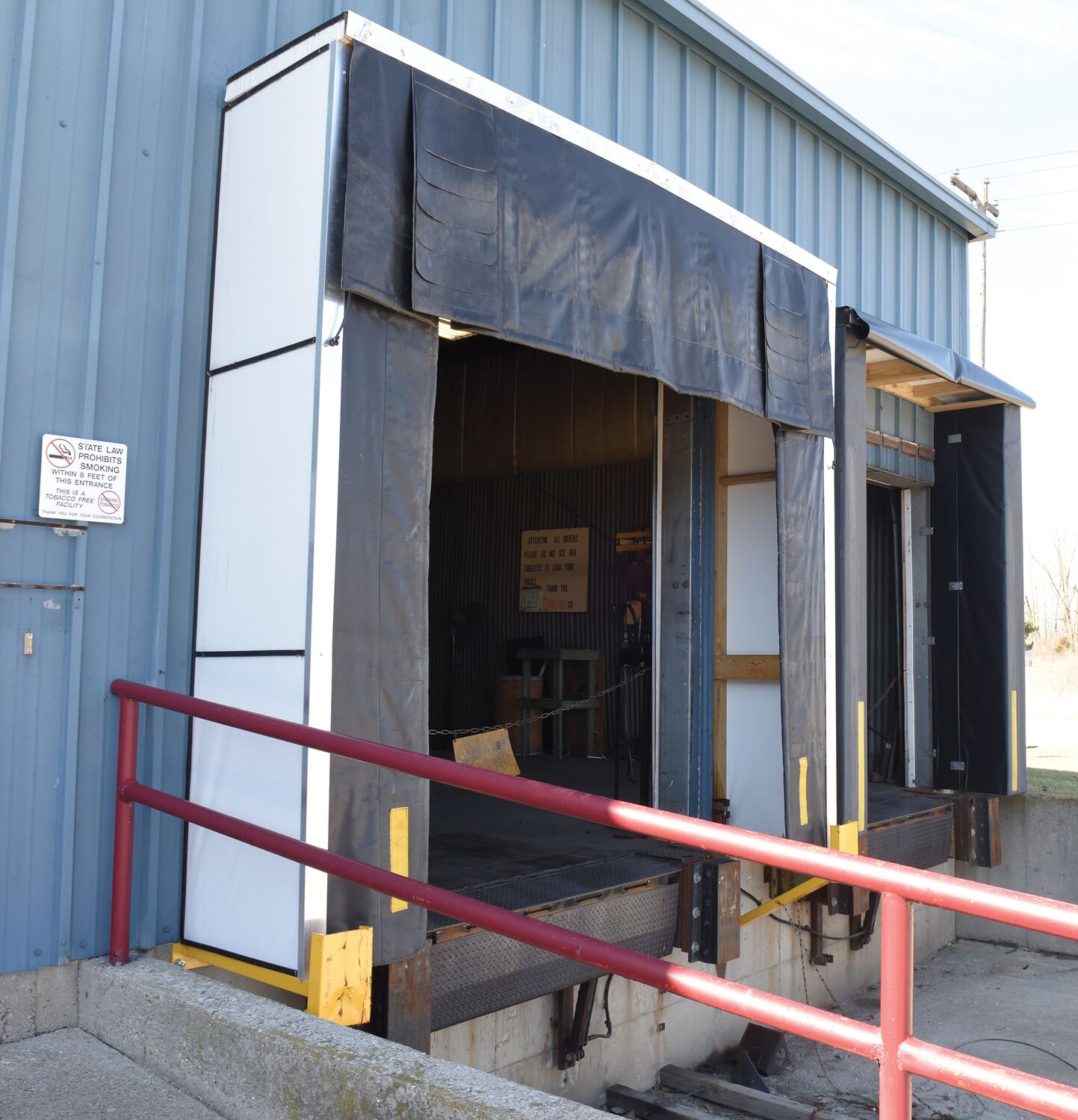 Loading dock with open doors and a red railing.