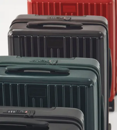 Four suitcases in different colors arranged in a row.