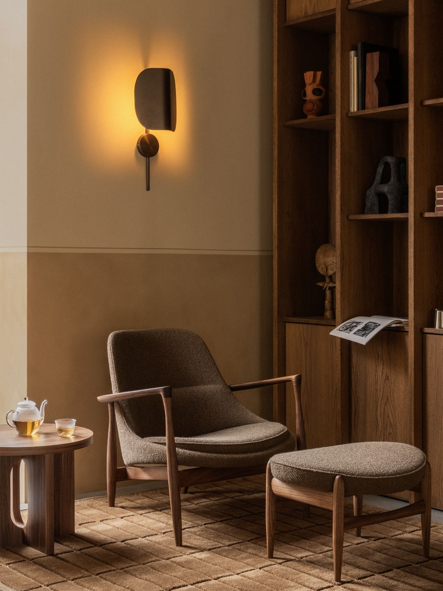 Cozy living space with a chair, ottoman, and wooden shelves.