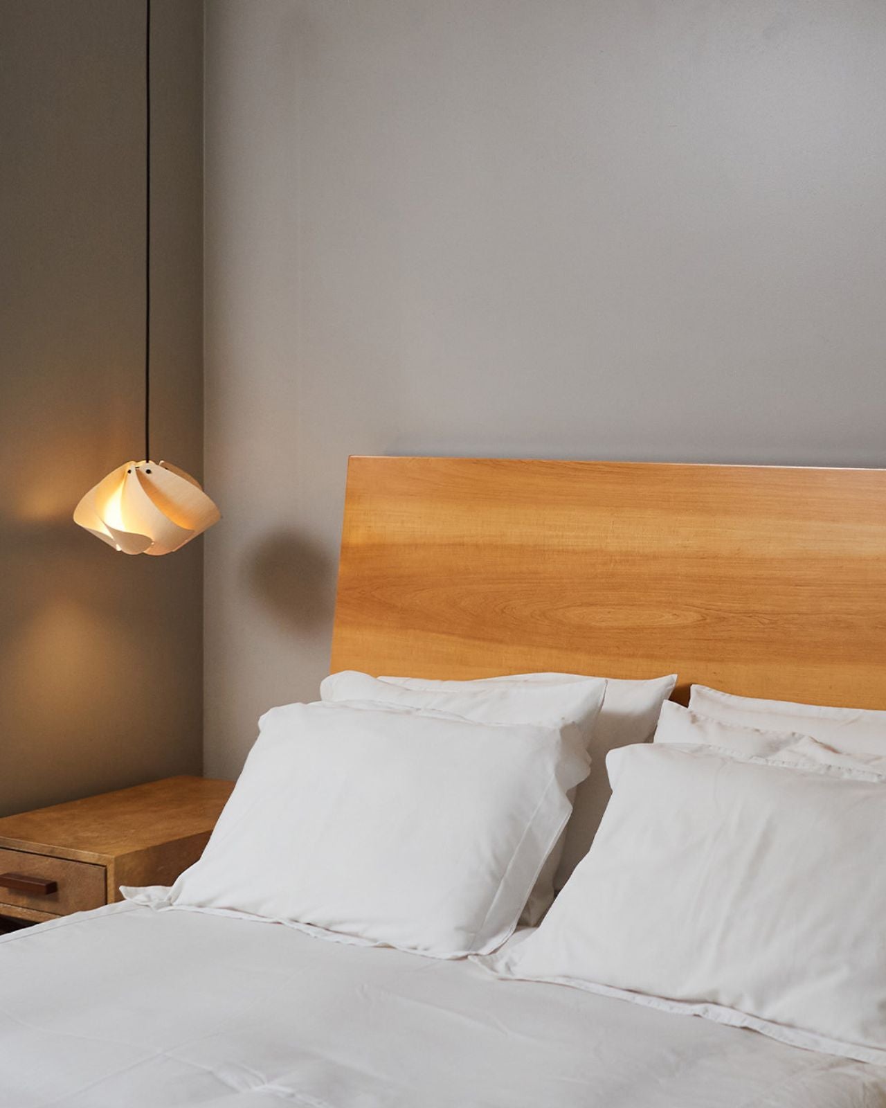 Abstract Timber Pendant Light hanging alongside a modern bed