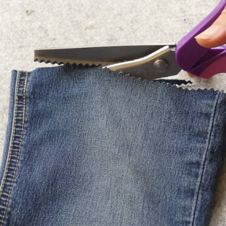 Finishing edges of a jeans with pinking shears 