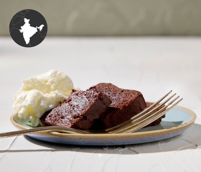 Chocolate dessert with whipped cream on a plate and fork.