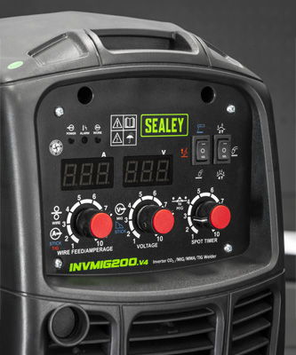 Control panel of a welding machine with digital displays and adjustment knobs.