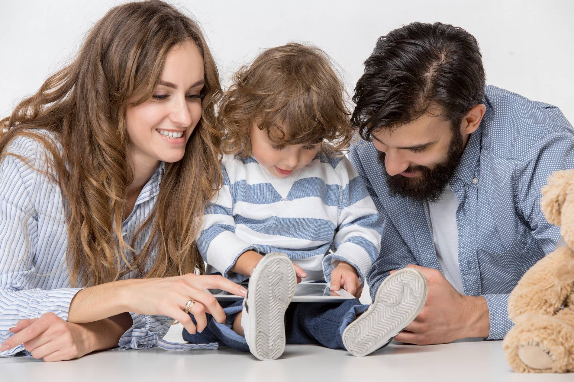 Mother, father, and child looking at an iPad